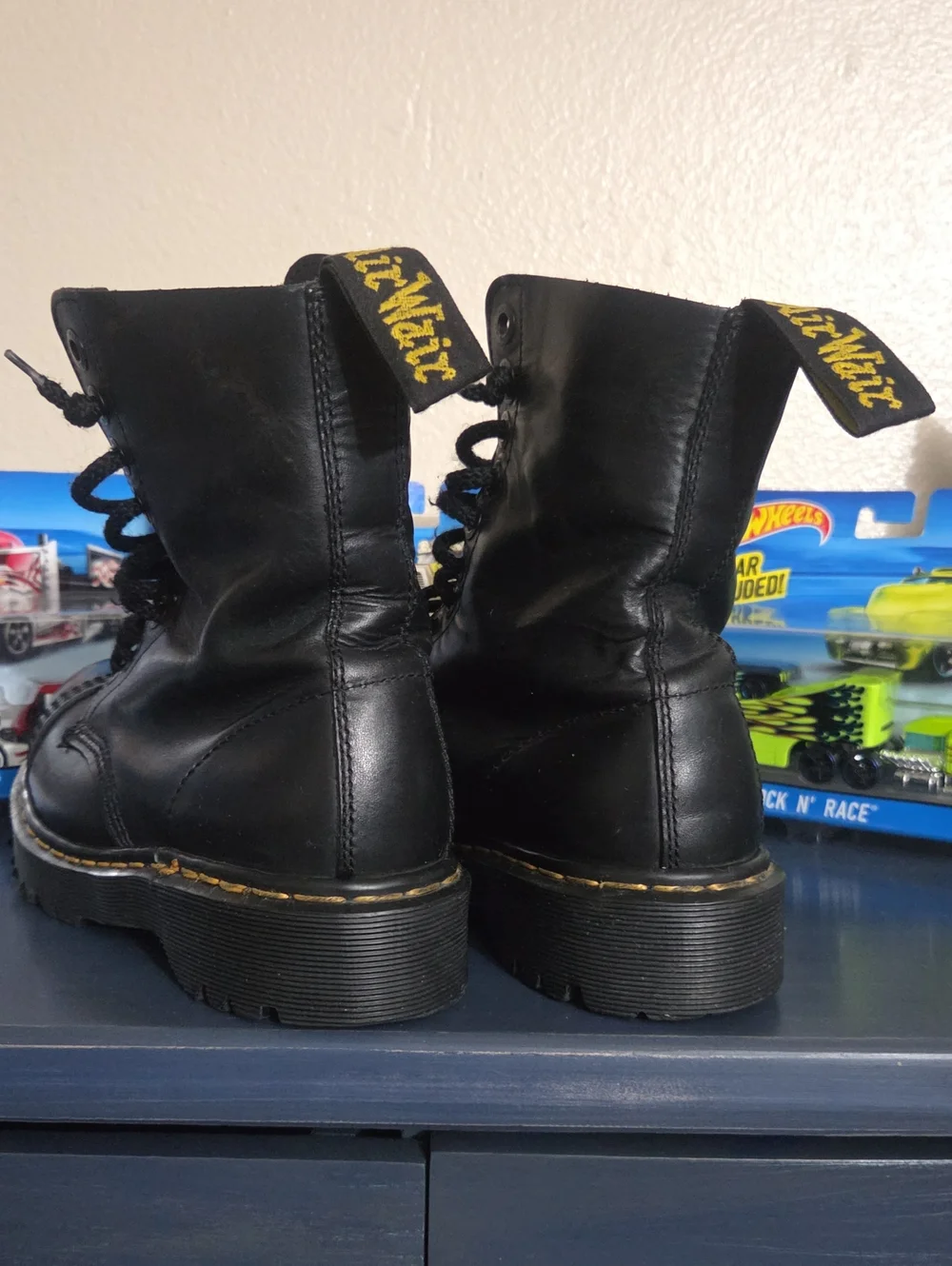 Dr. Martens steel toe black leather lace-up combat boots.